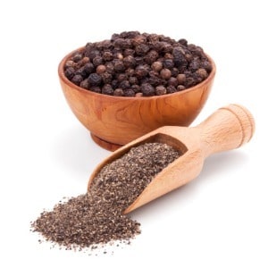 black peppercorns in bowl and ground pepper