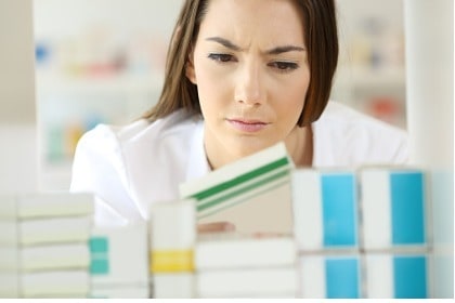 confused woman looking at items on shelf in drugstore