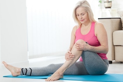 woman working on at home holding knee