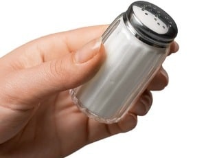 hand hold salt shaker of table salt