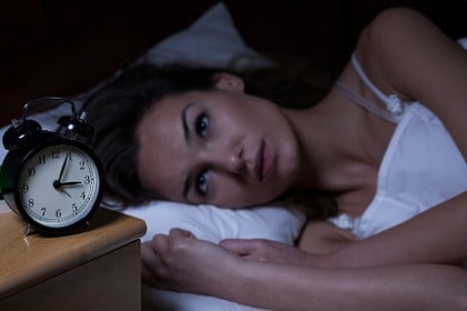 woman-with-insomnia-lying-in-bed-looking-at-clock