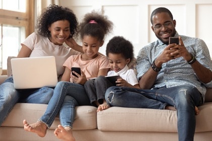 family-with-kids-relax-on-couch-using-digital-devices