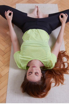 woman-in-reclining-bound-angle-yoga-pose-Supta-Baddha-Konasana