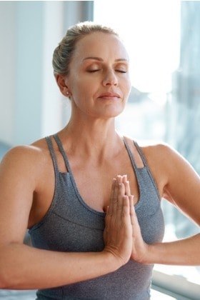 woman-practicing-yoga-meditation-at-studio-facing-right