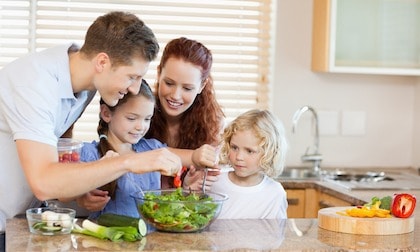 family making salad in kitchen
