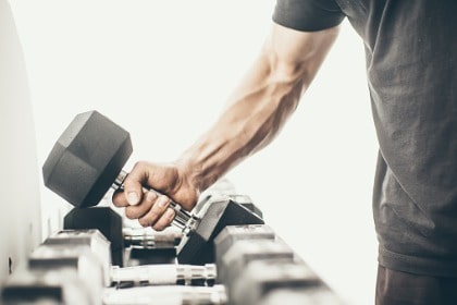 man's arm lifting weight at gym