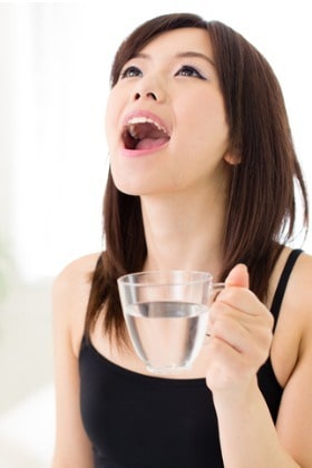 young-woman-gargling-with-warm-water