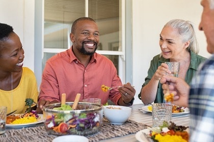 mature-men-and-women-eating-healthy-food-together-at-table