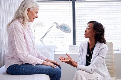 female patient sitting on examination table consulting with doctor