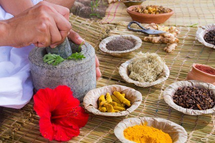 ayurvedic-doctor-preparing-herbs-including-turmeric-root