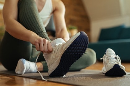 closeup-of-athletic-woman-putting-on-sneakers