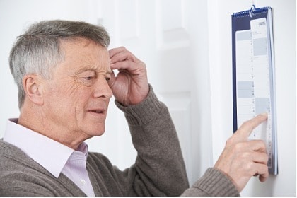confused-senior-man-with-dementia-looking-at-wall-calendar