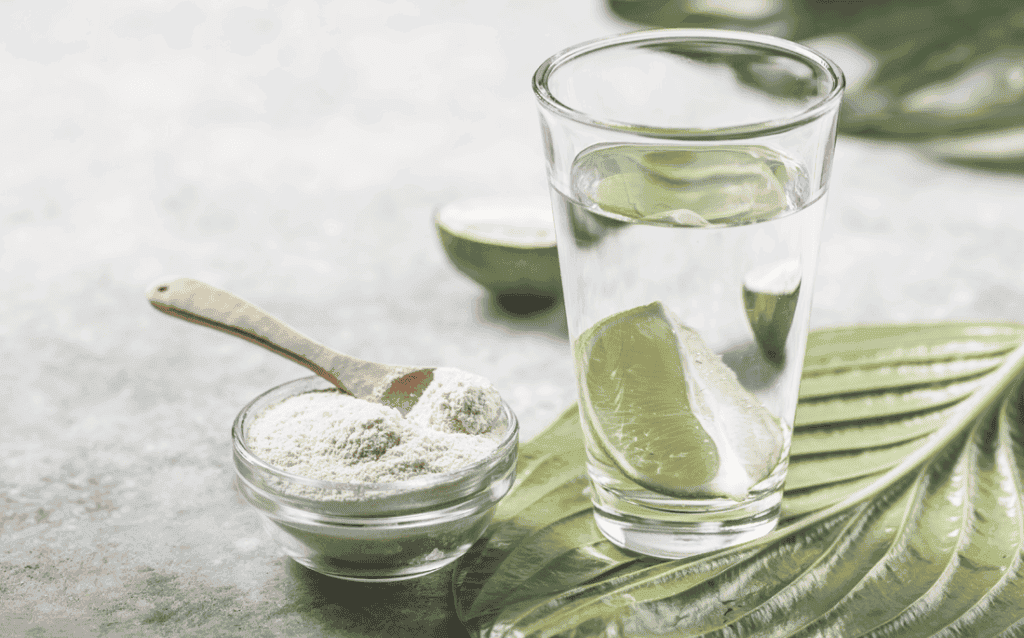 Photo showing powdered collagen supplement and a glass of water.