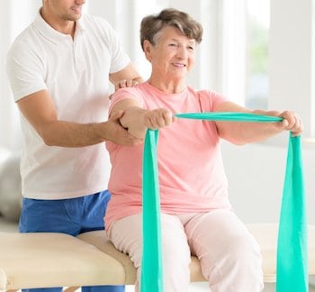 Elderly woman doing active pnf exercises with a teal scarf
