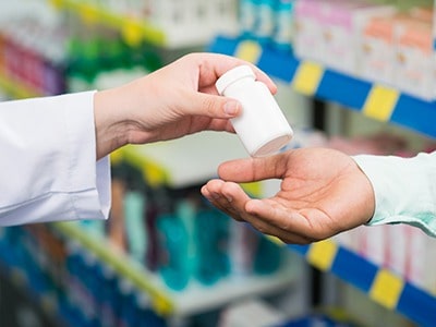 Doctor Hands Supplement Bottle to Customer