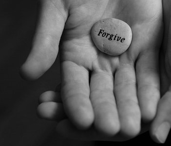 hand holding forgive stone