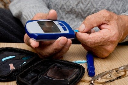 man checking blood sugar level with glucometer