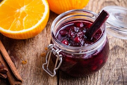 cranberry sauce in glass jar with cinnamon stick