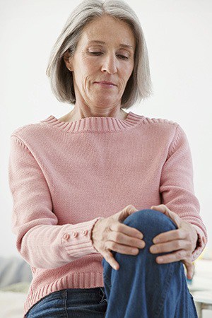 Mature Woman holds knee in pain