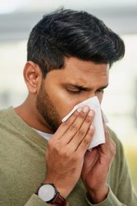 man with cold or flu blowing his nose