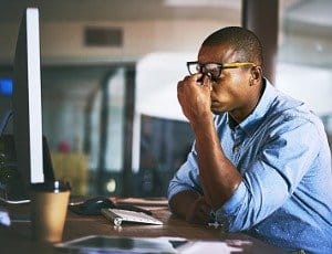 stressed out man sitting at desk at work