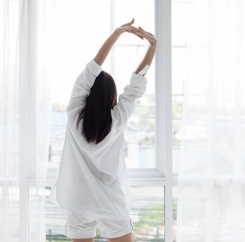 woman waking up and stretching